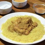 Chicken with a saffron onion sauce sits atop a bed of steamed broken angel hair pasta.